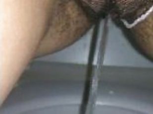 Girl pissing in public toilet with tampon inside. Very hairy pussy